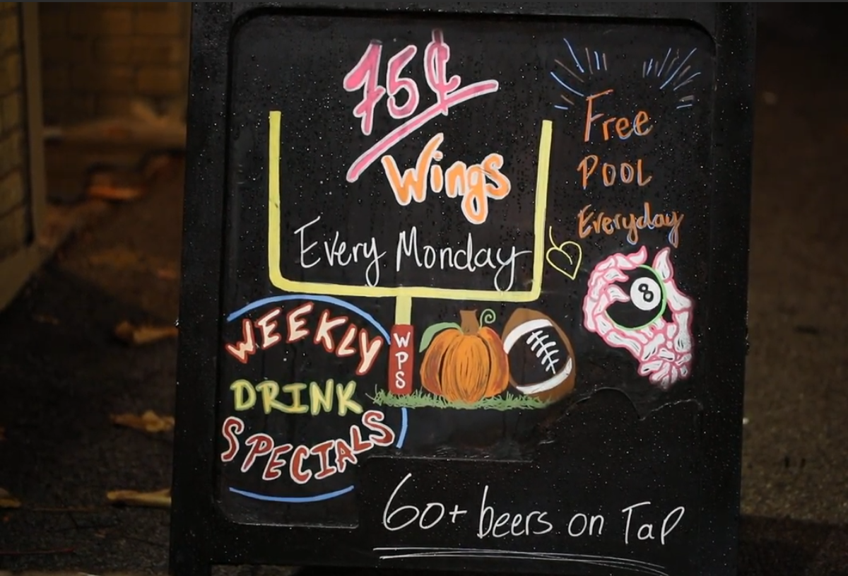 Photo of a sidewalk sign advertising Sideways' Wing Night